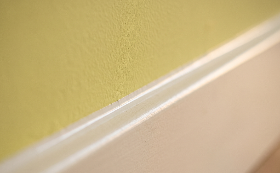 Strak afgewerkte kitnaad in de hoek tussen plint en wand
